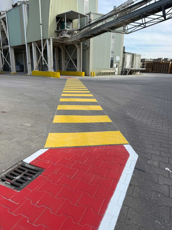 Detail van rode en gele veiligheidsmarkering op klinkers